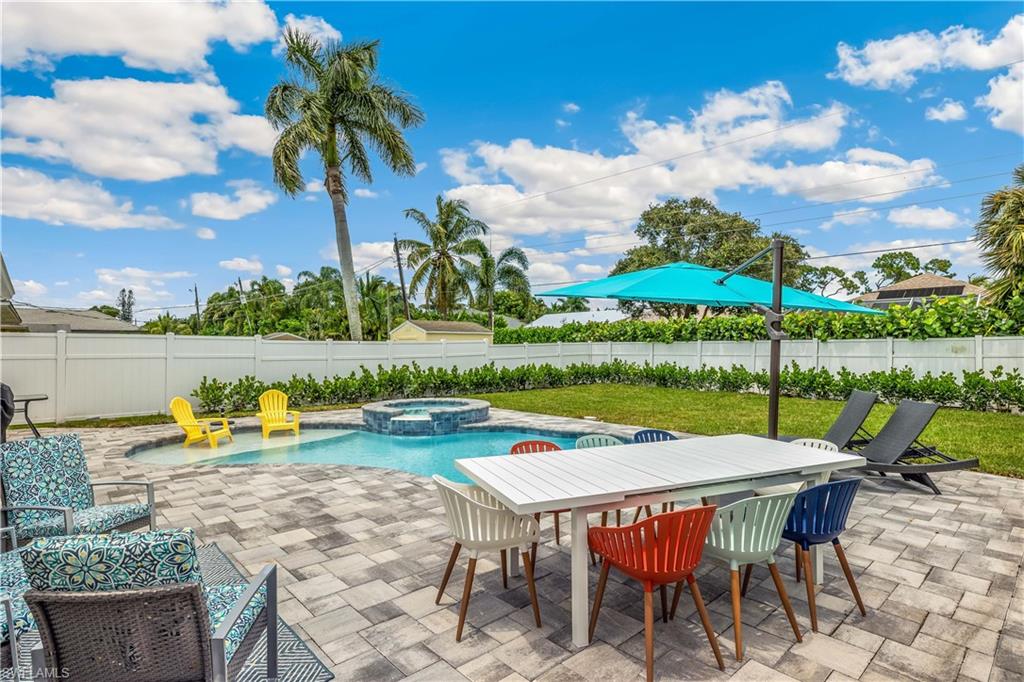 View of patio with a swimming pool with hot tub