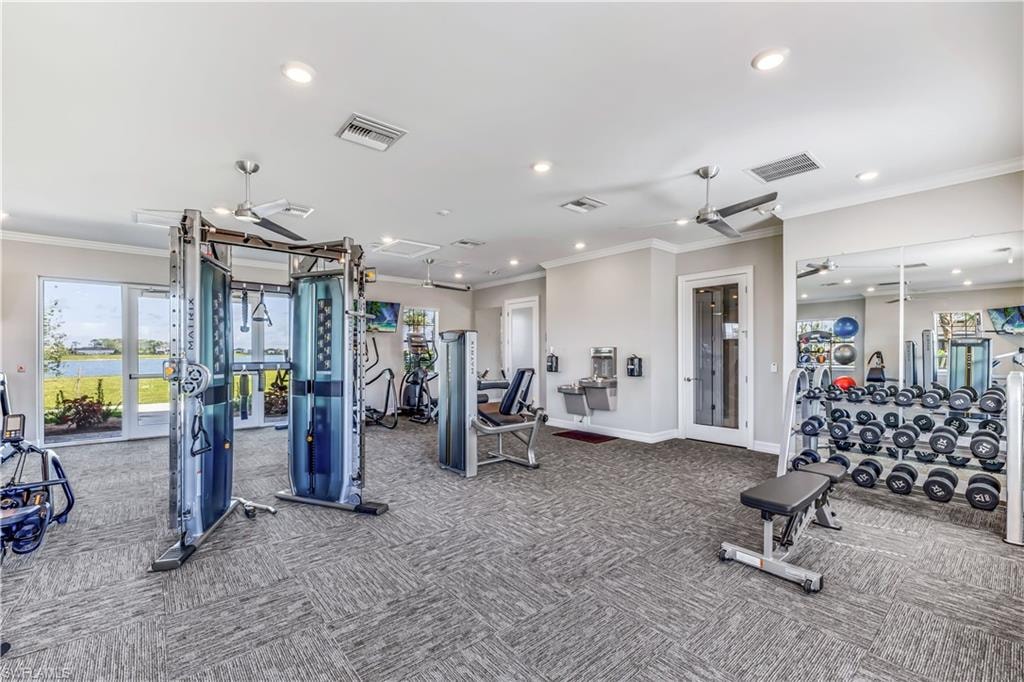 Fitness center featuring carpeted flooring, mirrored wall, recessed lighting, and ceiling fans