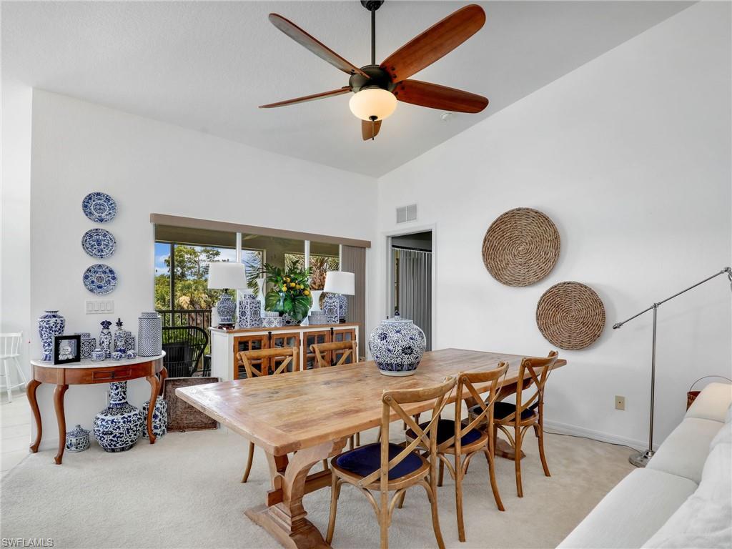 Vaulted ceilings, a full-lite glass door, and a ceiling fan with light fixture
