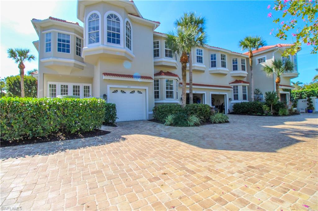 View of front of property with decorative driveway, an attached garage, and stucco siding