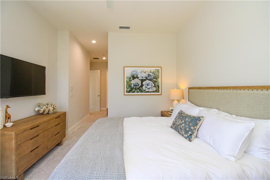 Bedroom with light carpet, visible vents, and recessed lighting