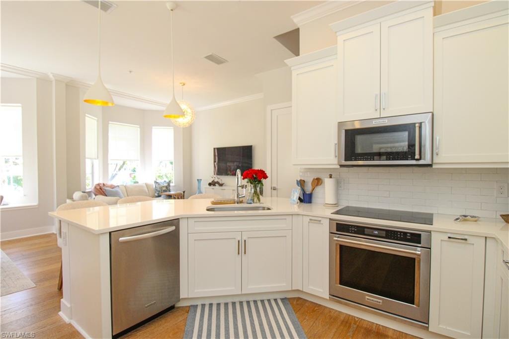 Kitchen with a sink, stainless steel appliances, light countertops, and open floor plan