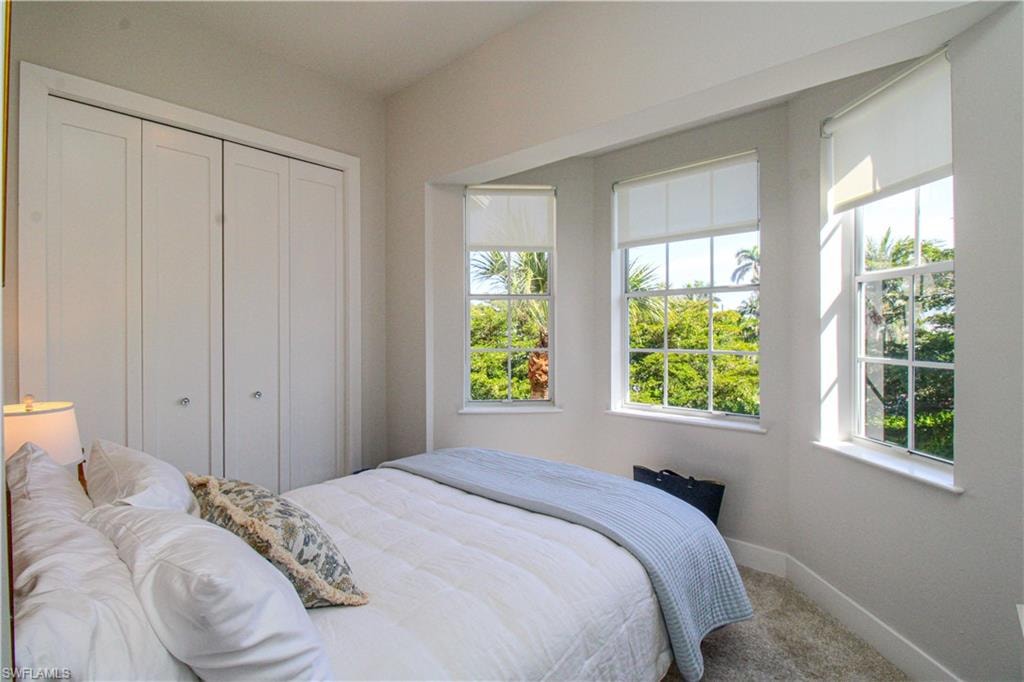 Carpeted bedroom with a closet and baseboards