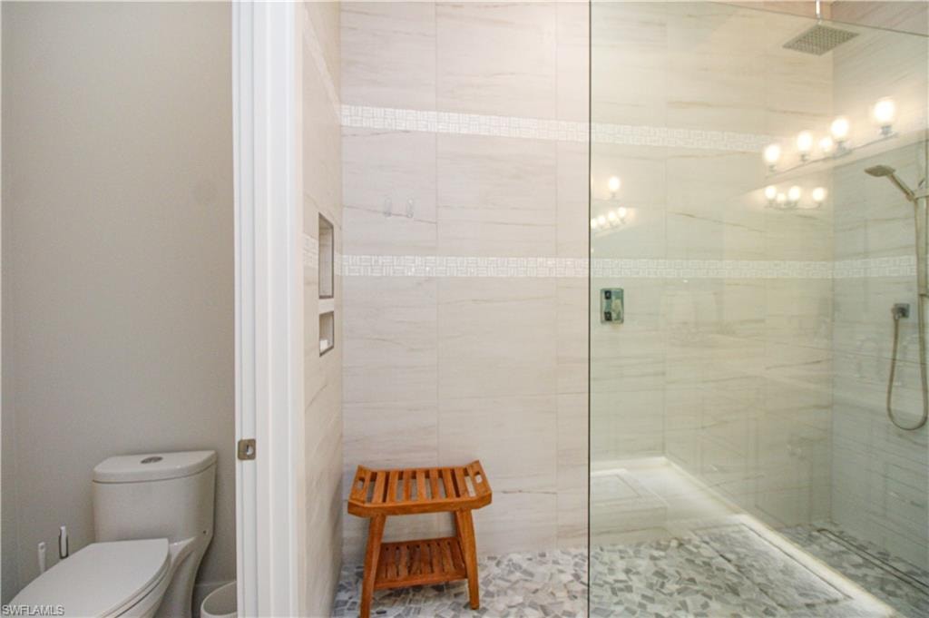 Bathroom featuring a stall shower, visible vents, and toilet