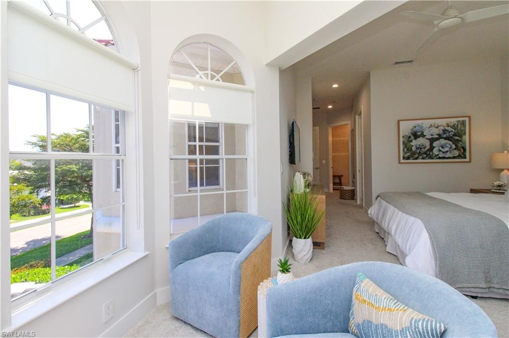 Bedroom with a towering ceiling, recessed lighting, multiple windows, and light colored carpet