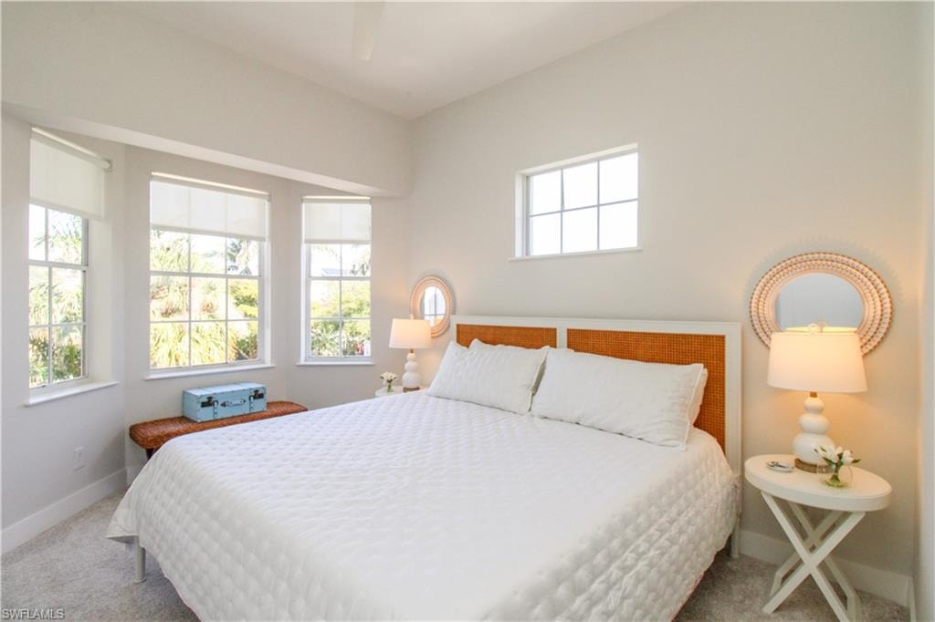 Bedroom featuring carpet floors, multiple windows, and baseboards
