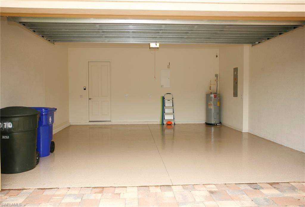 Spacious garage featuring a durable epoxy floor, a water heater, and a utility access panel