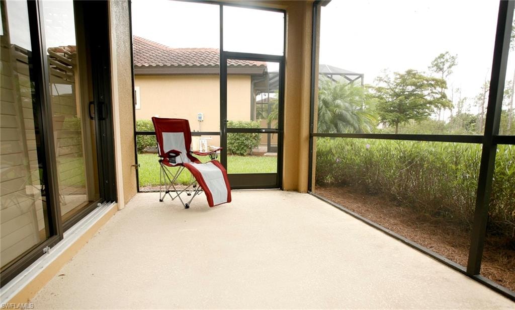 Screened patio with a concrete surface and sliding glass door access
