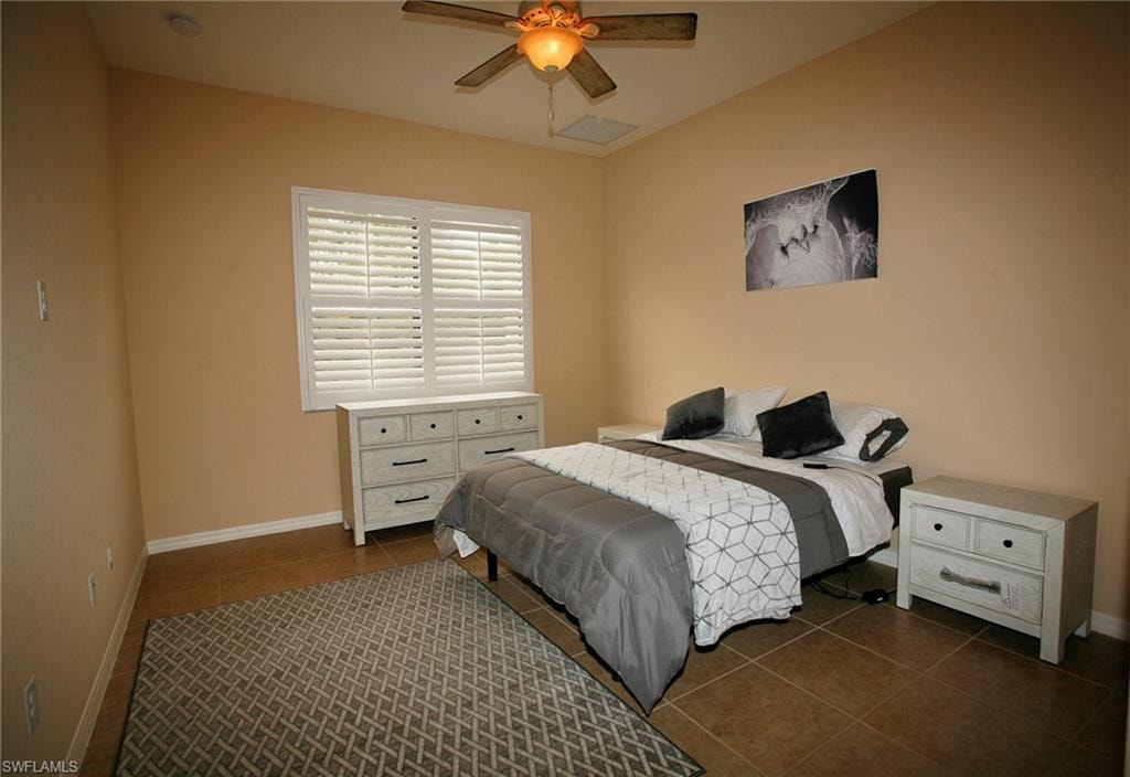 Recessed lighting, ceiling fan with light fixture, tiled flooring, and window with plantation shutters