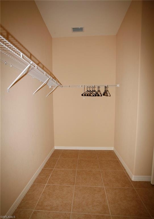 Tiled flooring with a neutral finish, complemented by a white wire shelving system and a clothing rod