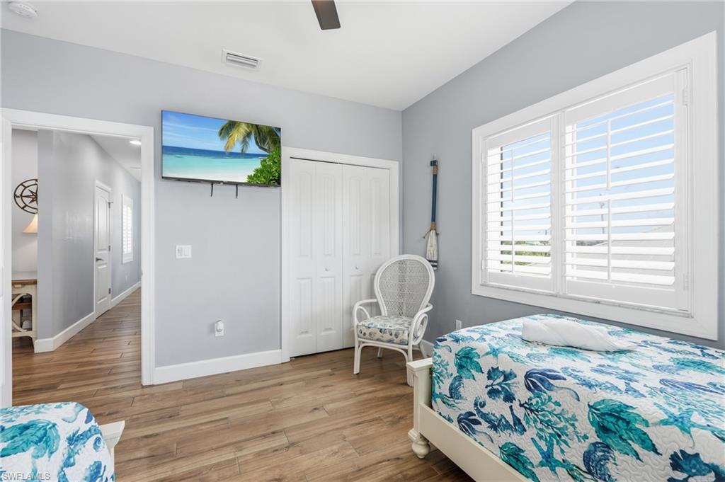 Wood-finish flooring, plantation shutters, and a ceiling fan - Virtually Edited Image