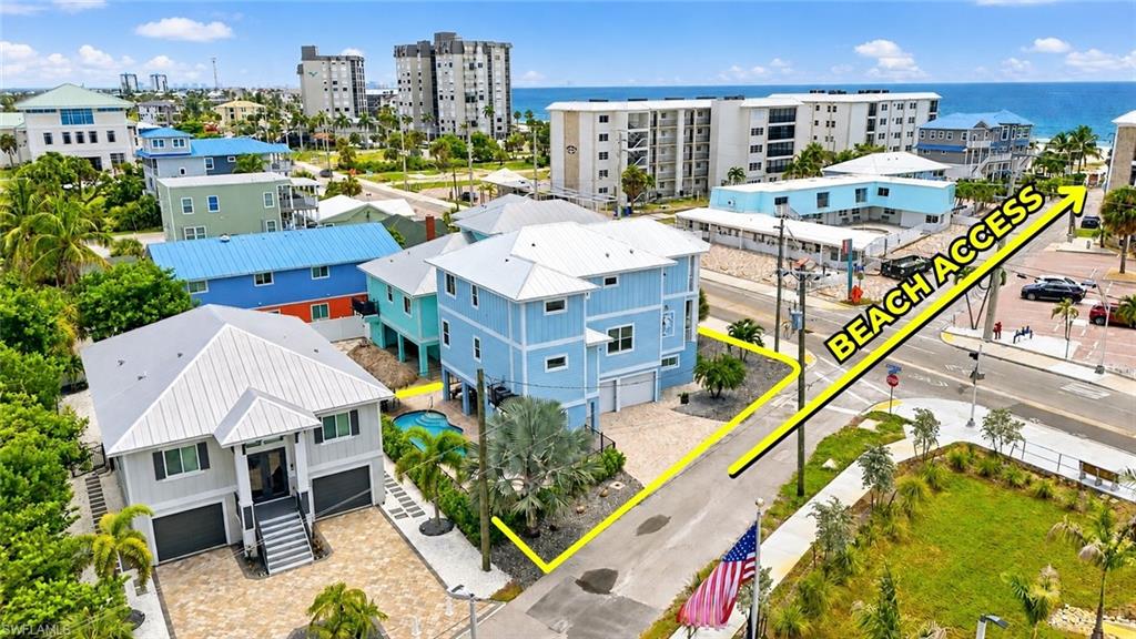 Coastal property featuring two multi-story residences, a private pool, and a paved driveway