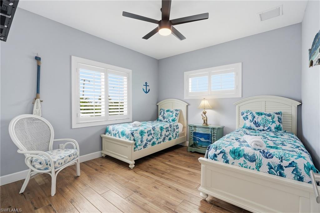 Wood-finish flooring, white window shutters, and a ceiling fan with integrated lighting - Virtually Edited Image
