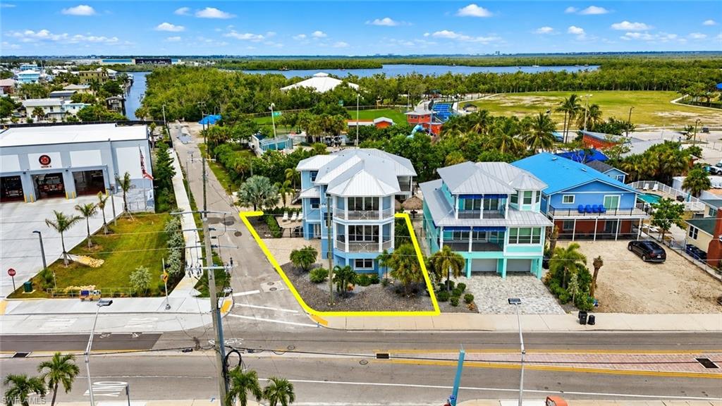 Elevated coastal-style architecture with multiple balconies, a metal roof, and a paved driveway - Virtually Edited Image