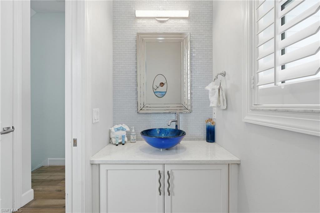 Custom vanity with a vessel sink, integrated cabinetry, and stone countertop - Virtually Edited Image