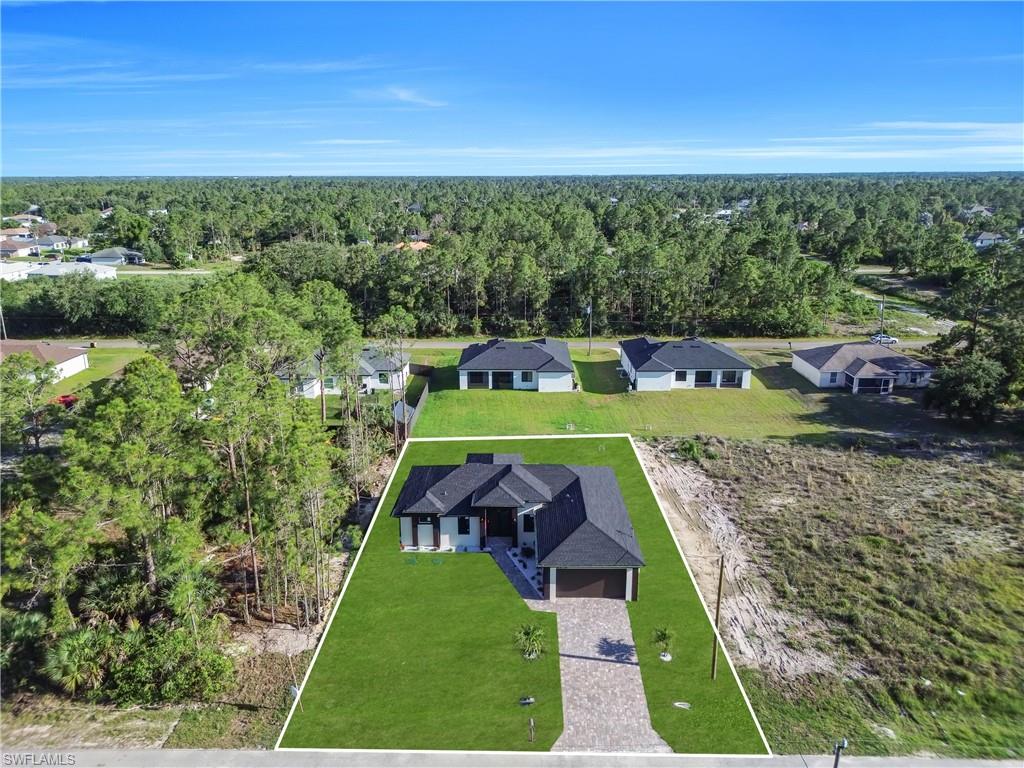 Contemporary single-story residence featuring a dark shingle roof, light-colored exterior, and a paver driveway