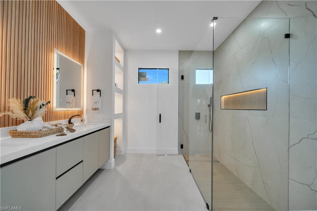 Walk-in shower with full height glass enclosure and illuminated niche