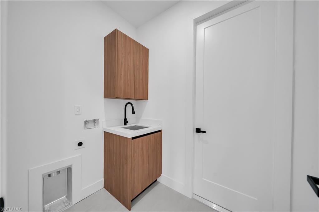 Wood-finish cabinetry with a built-in sink, matte black faucet, and white countertop