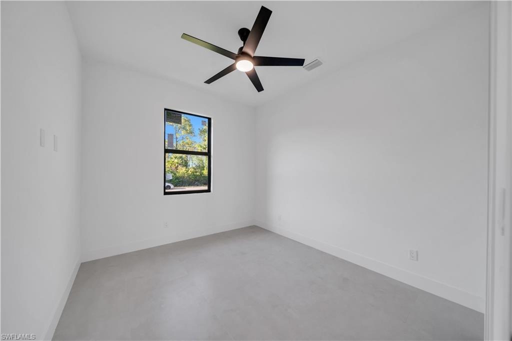White walls with a black-framed window, a ceiling fan with integrated lighting, and light-toned flooring