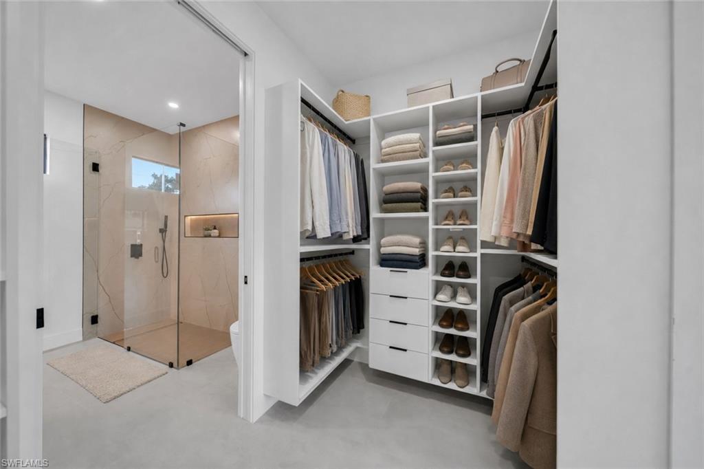 Integrated custom closet system with hanging rods, shelving, and drawers