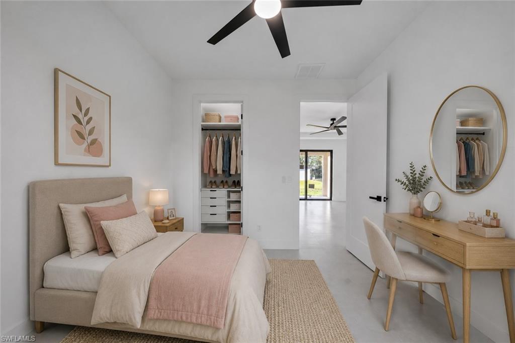 White walls, ceiling fan, open closet with built-in shelving, wood-finish flooring, and a solid core door