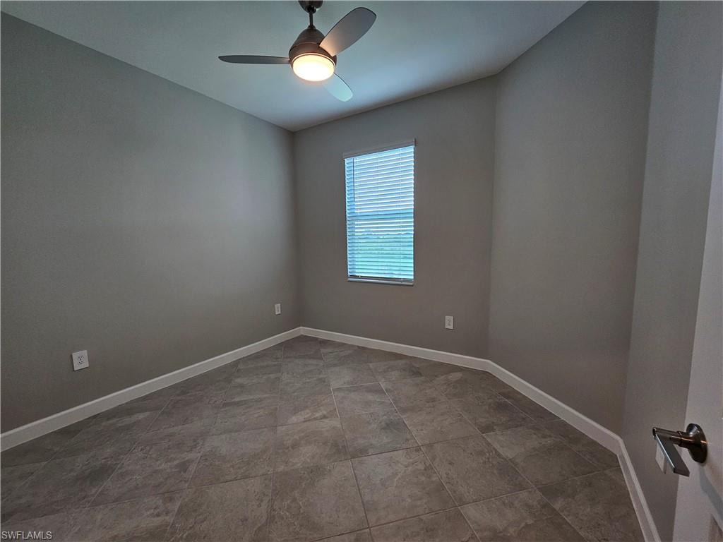 Neutral tone paint finishes, tile flooring, window with blinds, and a ceiling fan with integrated lighting
