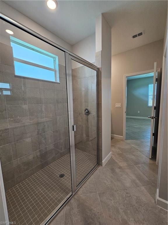 Glass-enclosed shower with a tiled surround and mosaic floor