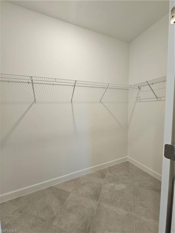 Expansive closet featuring wire shelving, white painted walls, and light gray tile flooring
