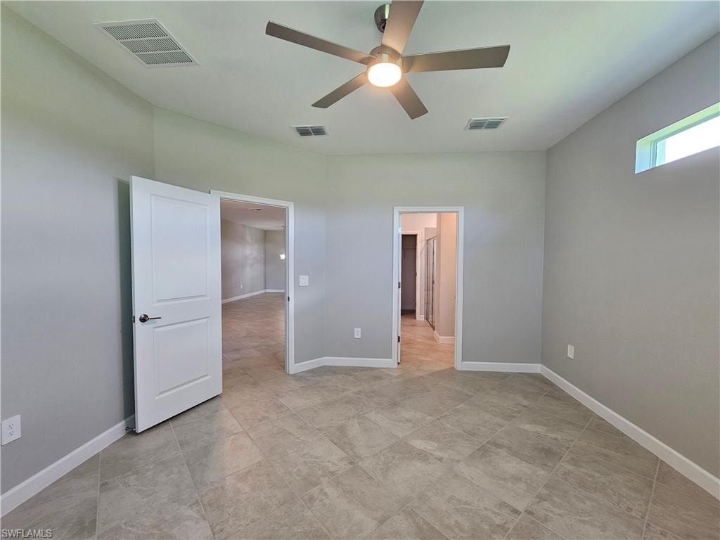 Neutral wall tones, tiled flooring, ceiling fan, and horizontal window