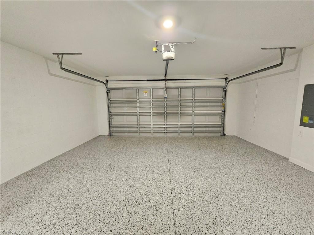 Spacious garage with an epoxy-coated floor and a raised panel garage door