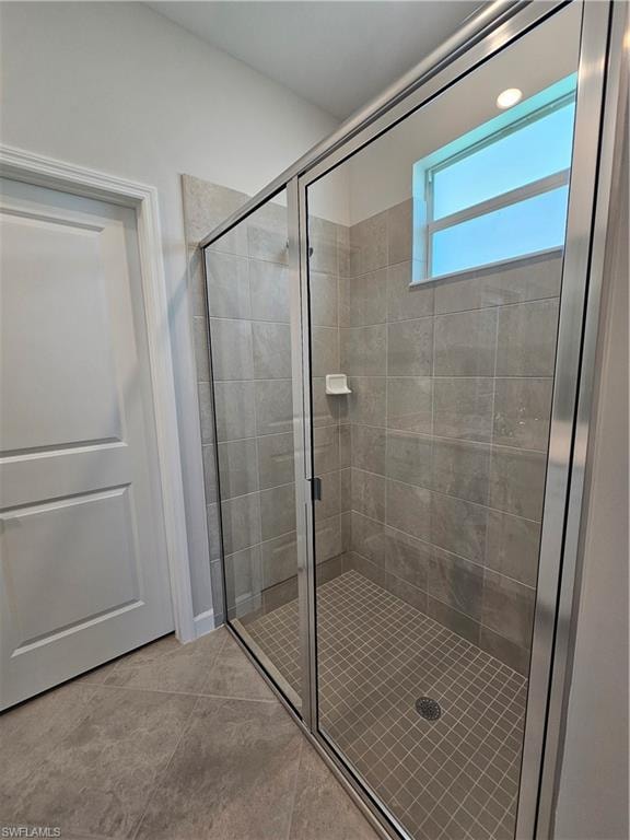 Glass-enclosed shower with tile walls and a tiled shower pan