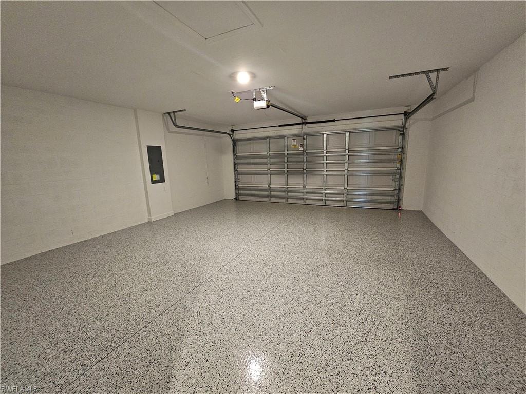 Epoxy speckled flooring, white painted walls, and an automatic garage door system