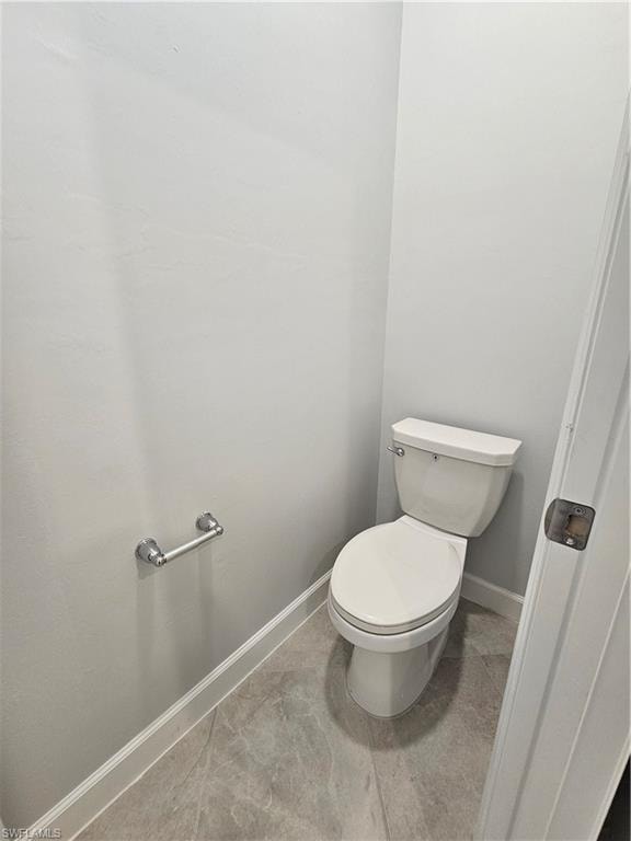 White toilet with a chrome toilet paper holder