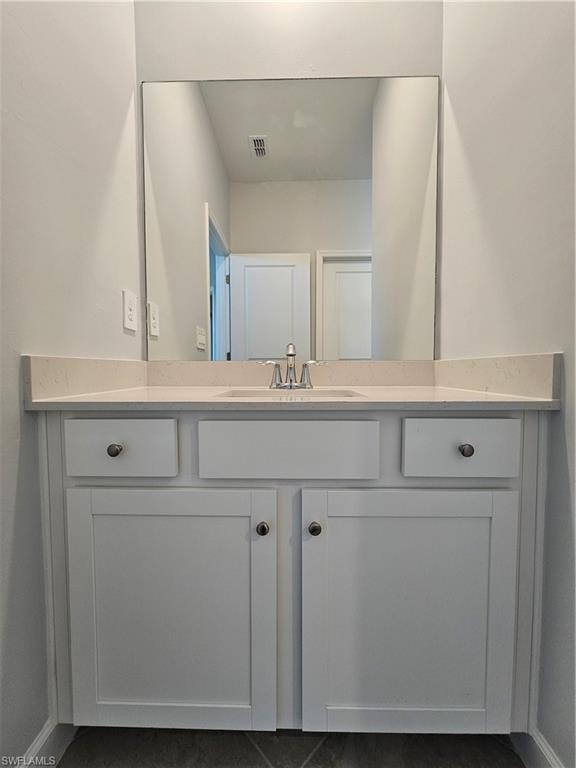 White vanity with recessed panel doors, flat-panel drawers, and a light-toned countertop featuring an undermount sink