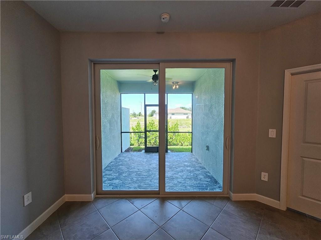 Sliding glass door leading to a screened patio with a ceiling fan