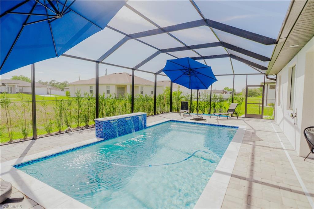 Pool featuring a patio area, a lanai, and a hot tub