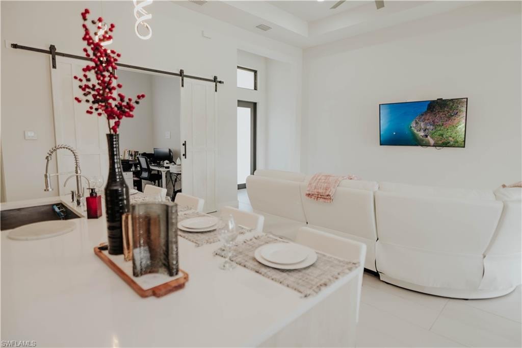 Dining space featuring a barn door and ceiling fan