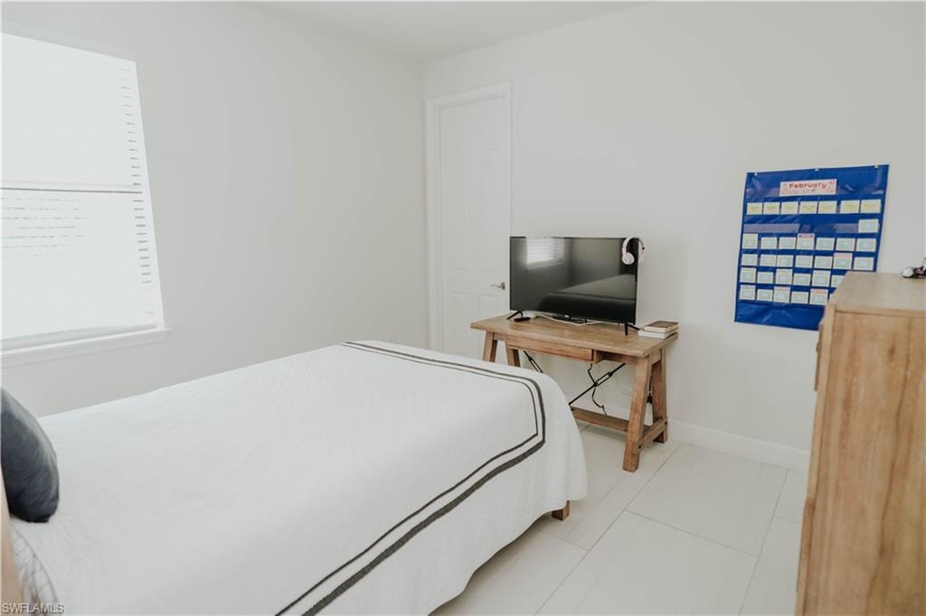 Bedroom featuring light tile patterned floors and baseboards