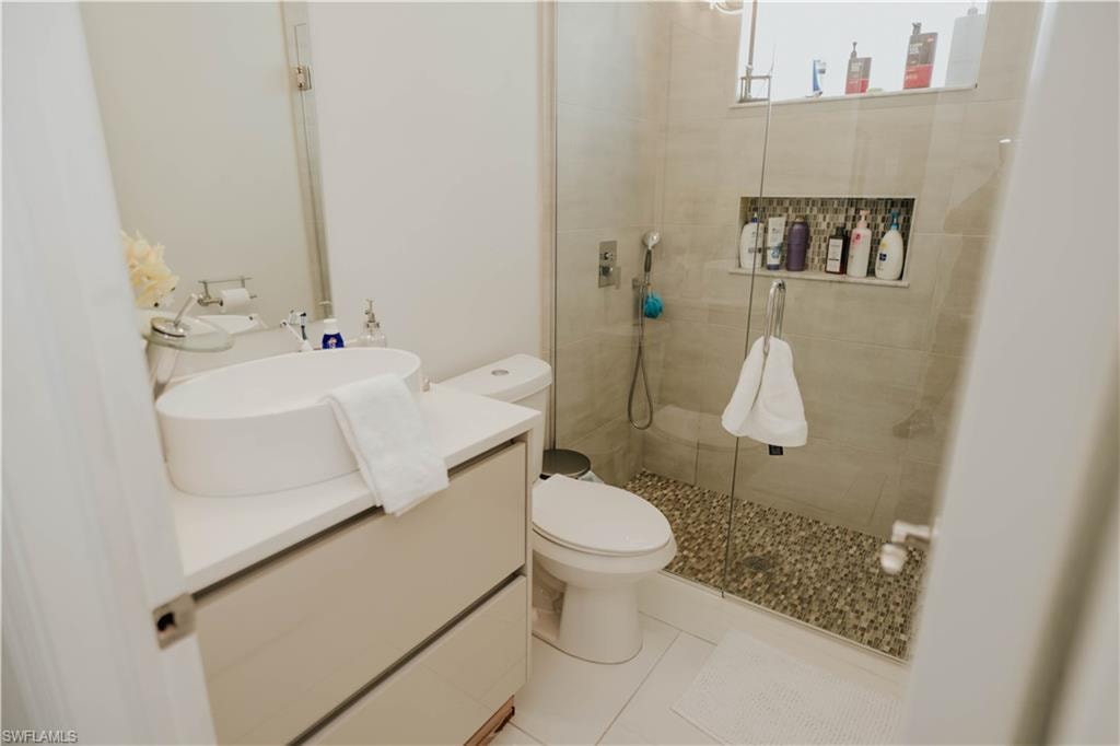 Full bath with a stall shower, vanity, toilet, and tile patterned floors