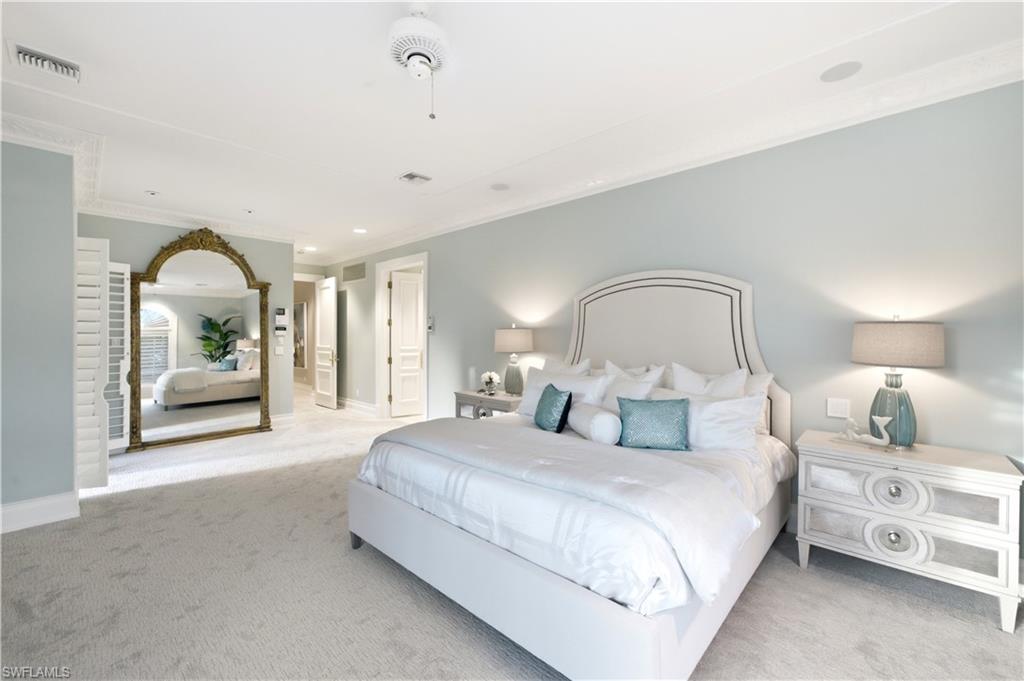 High ceilings with crown molding, recessed lighting, and light-toned carpeting