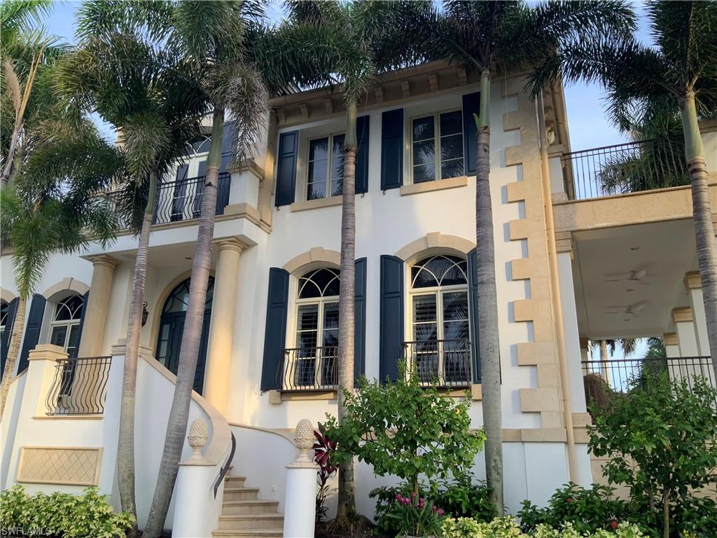 Stately exterior with decorative stone accents, arched windows, and dark louvered shutters