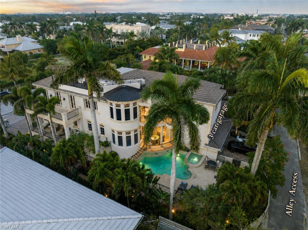 Mediterranean-style residence featuring a multi-level exterior, an integrated swimming pool with a spa, a three-car garage, and extensive landscaping