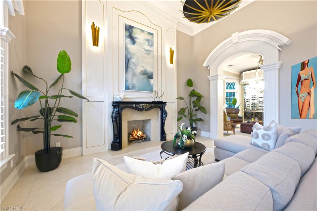 Decorative fireplace with ornate black mantel, white paneling, and an arched entryway