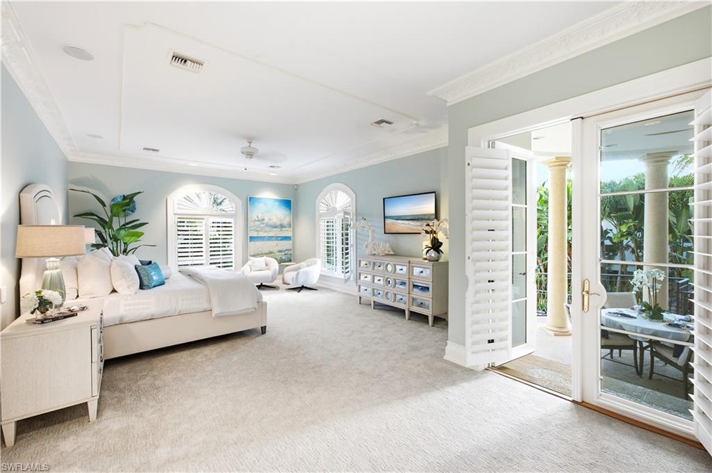 Expansive room with tray ceiling, crown molding, and light-colored carpeting