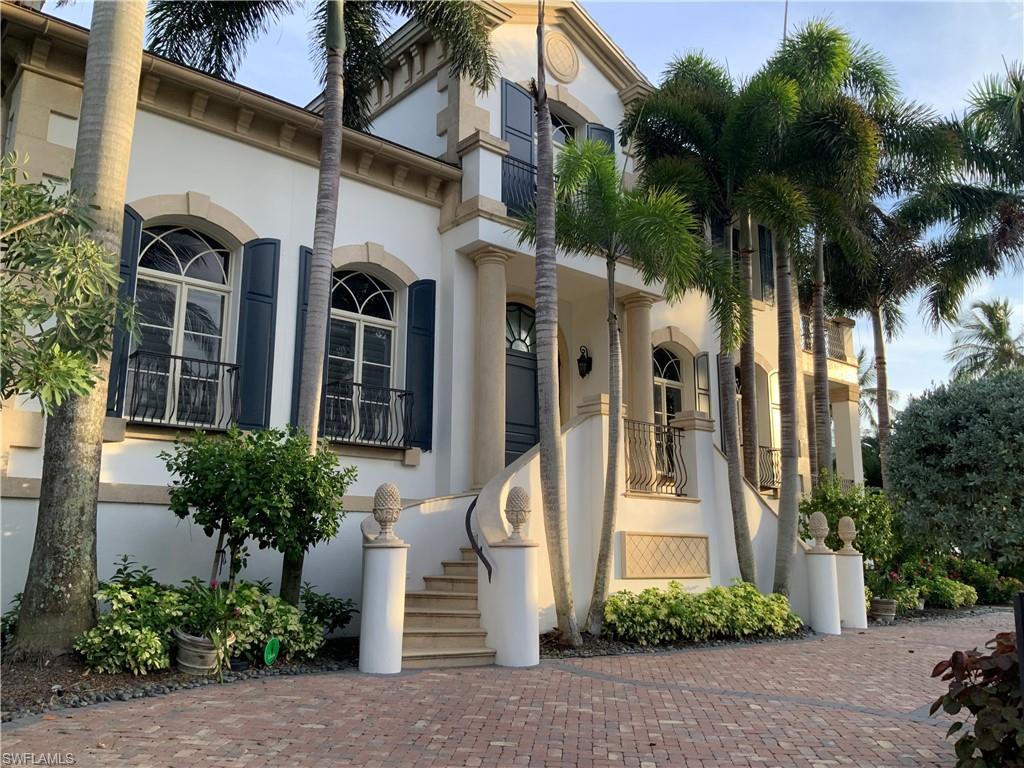 Stately exterior with decorative stone accents, arched windows, and dark louvered shutters