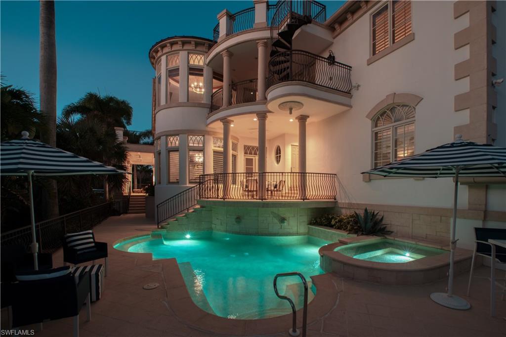 Outdoor aquatic area featuring a swimming pool, integrated spa, and surrounding patio