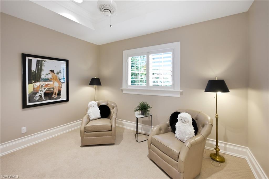 Recessed ceiling with a central fan, plantation shutters, and extensive crown molding