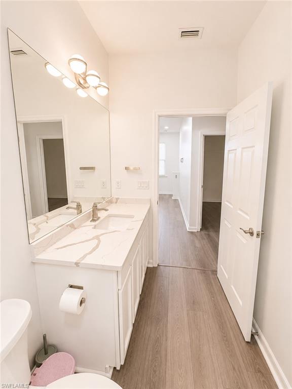 White vanity with integrated sink, quartz countertop, and brushed nickel fixtures