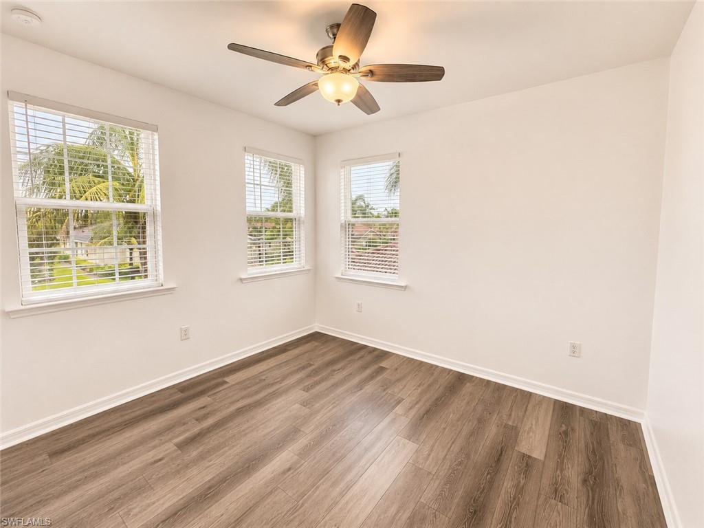 Wood-finish flooring with white trim and multiple windows