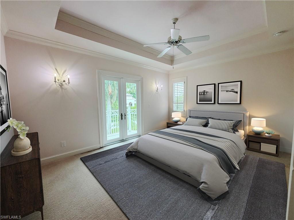 Tray ceiling with crown molding, double French doors with transom windows, plantation shutters, wall sconces, and a ceiling fan